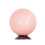 Gros plan du globe en verre de la petite lampe LAZIO Sphère, qui prend une teinte rose pâle lorsqu’il est allumé.