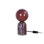 Petite lampe de table LAZIO Sphère éteinte, globe en verre bordeaux sur socle en marbre foncé veiné, hauteur 20 cm.