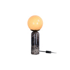 Lampe de table LAZIO Sphère allumée, globe lumineux sur pied en marbre foncé, avec câble et interrupteur noirs.