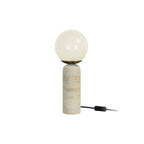 Lampe LAZIO Sphère crème allumée sur fond blanc, avec son pied en marbre clair et son interrupteur sur le câble noir.