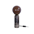 Lampe de table LAZIO Sphère éteinte, globe en verre marron sur socle cylindrique en marbre foncé veiné, hauteur 38 cm.