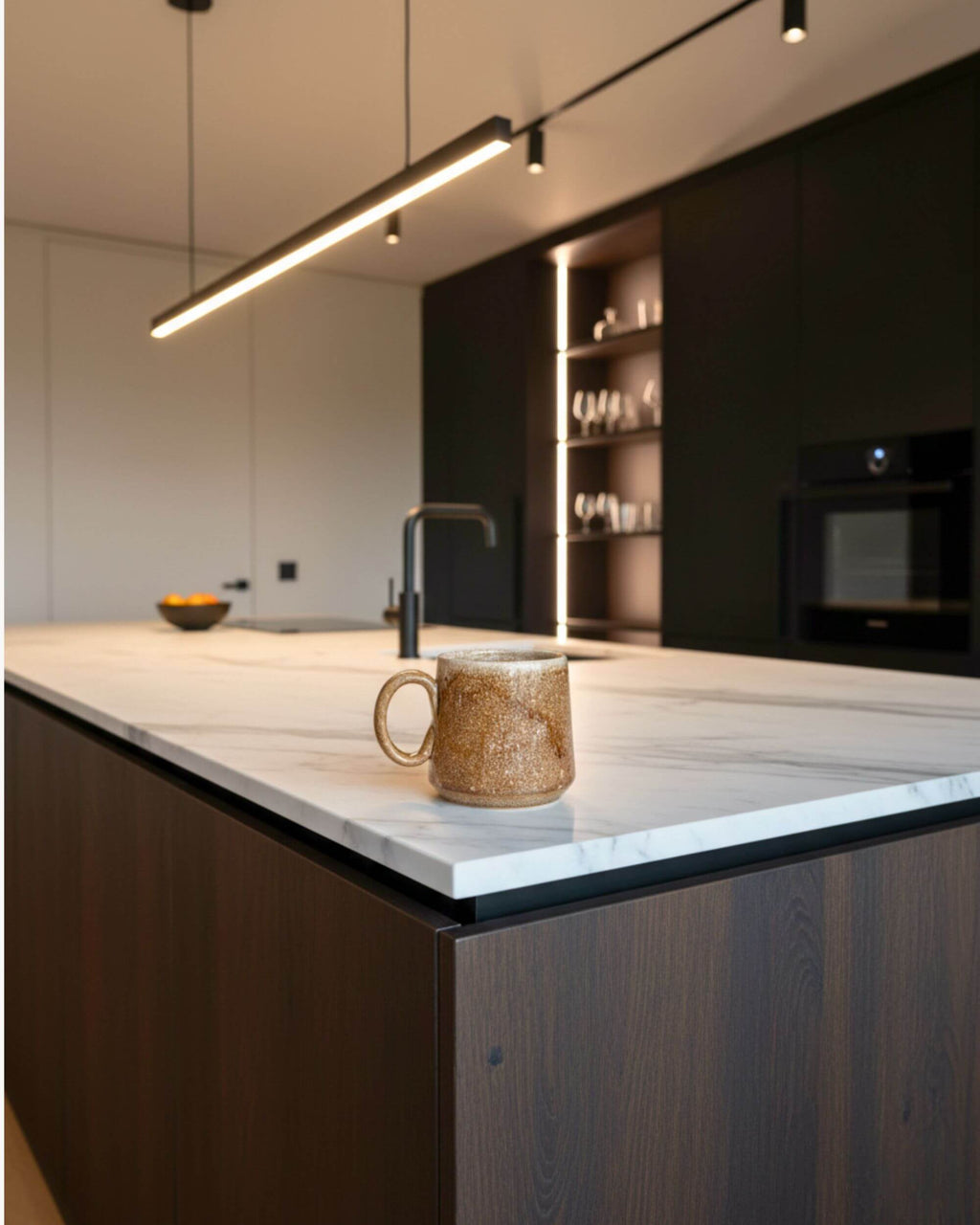 Mug artisanal KARAMELO beige et caramel posé sur un plan de travail en marbre