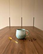 Mug artisanal vert aqua et blanc avec cuillère dorée