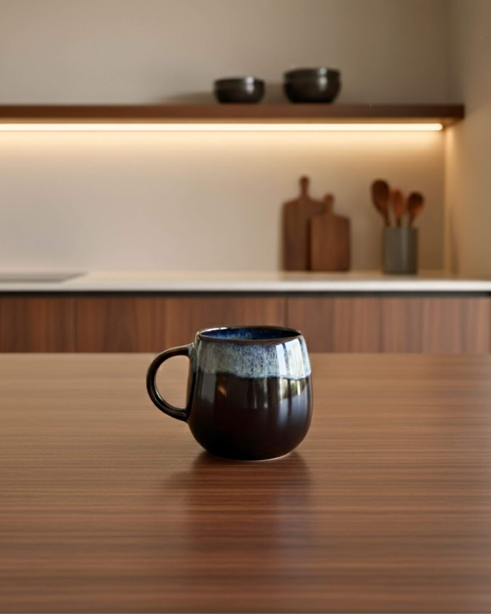 Mug UNIVERS bleu profond sur table en bois, céramique portugaise artisanale, ambiance douce et moderne.