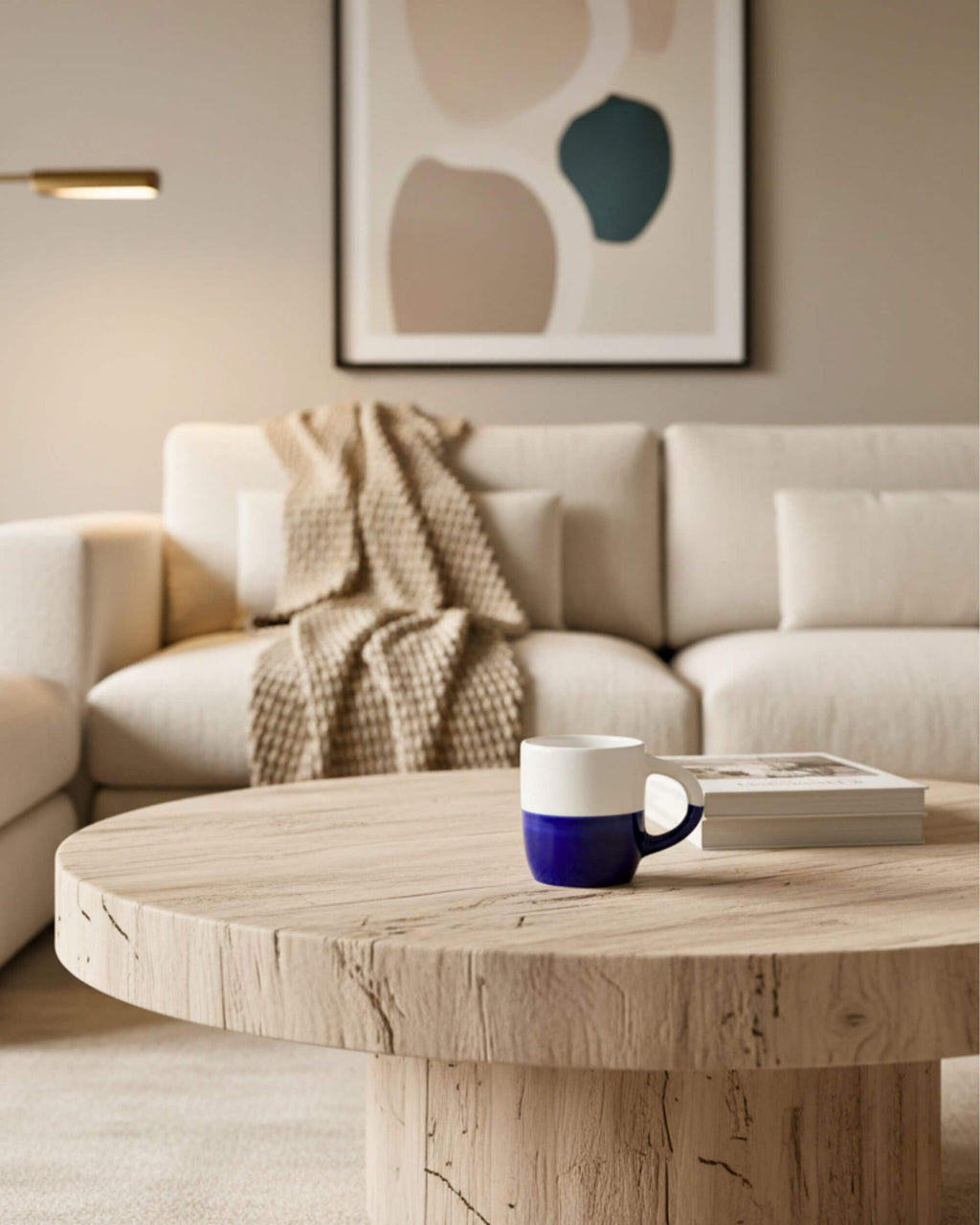 Mug MINERVA bleu et blanc posé sur une table basse en bois clair – design artisanal méditerranéen