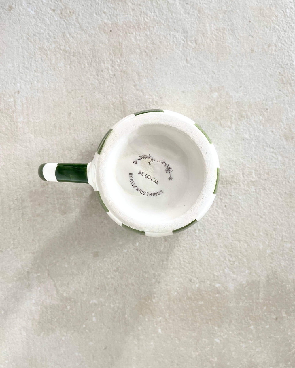 Vue de dessus du mug artisanal MINERVA rayé vert avec liseré rouge, intérieur crème – céramique espagnole.