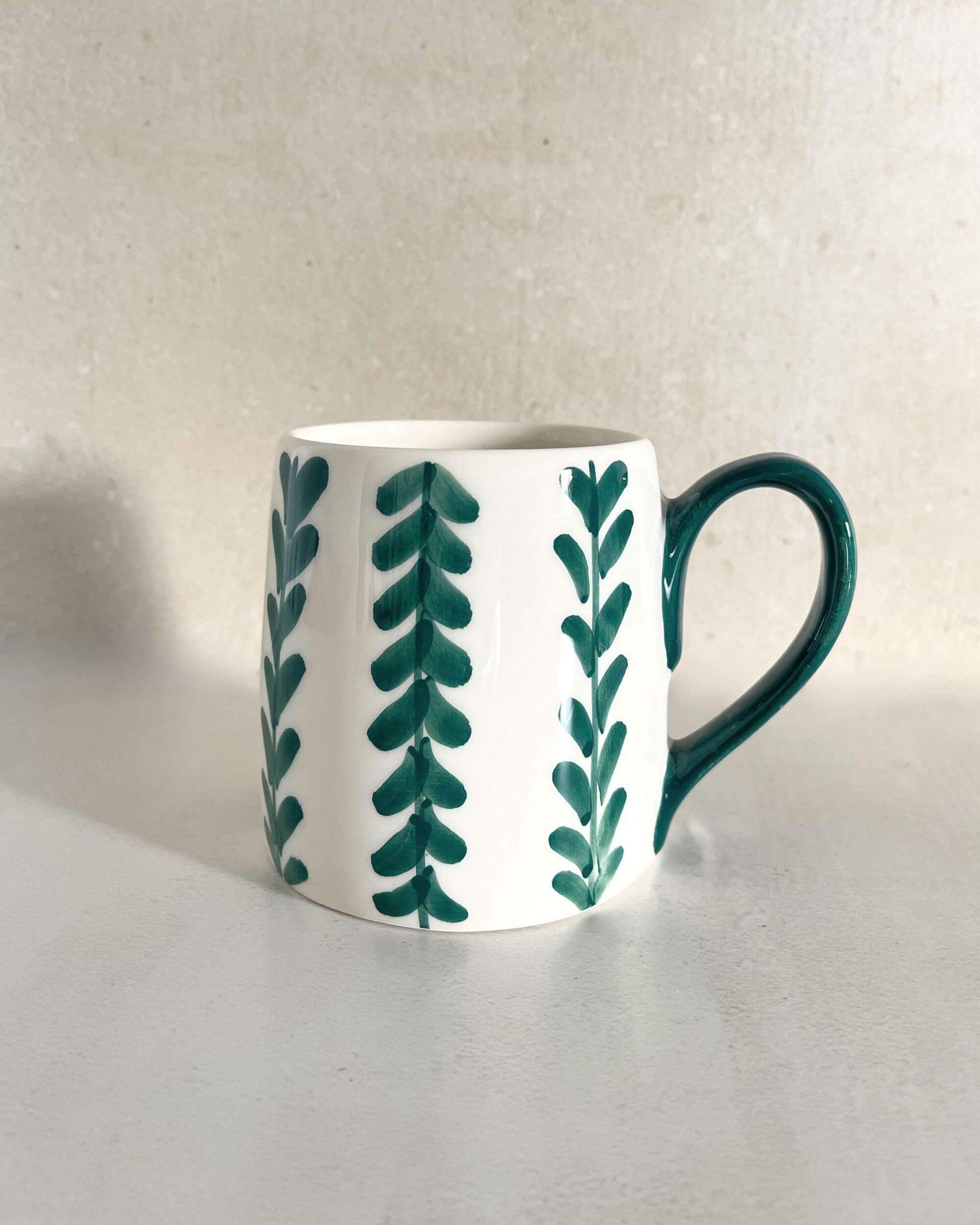 Gros plan sur le mug PAULA artisanal, céramique florale blanche et verte – savoir-faire espagnol