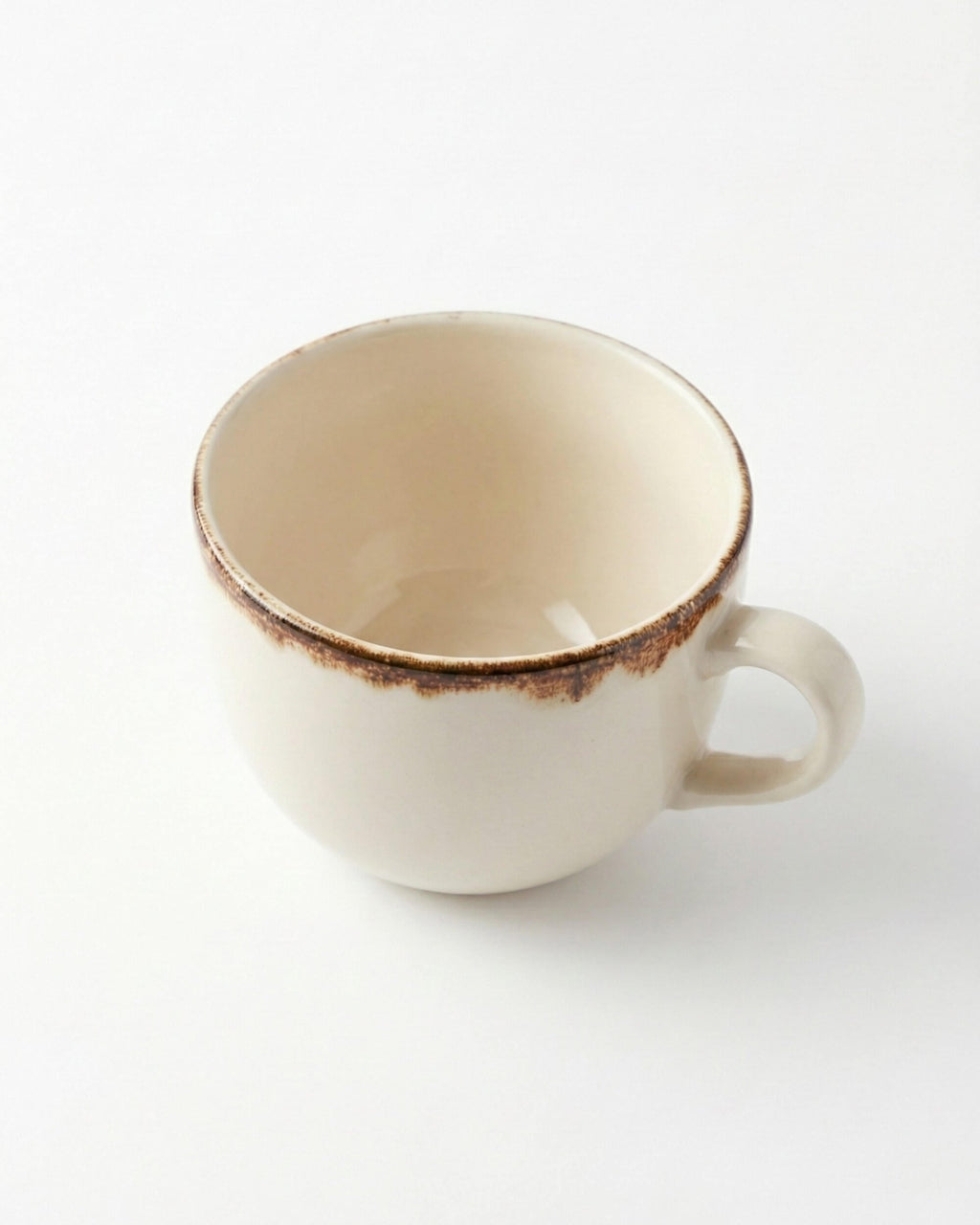 Vue de dessus et de l'intérieur de la grande tasse Sierra en céramique beige. Détail de l'anse et de l'émail.