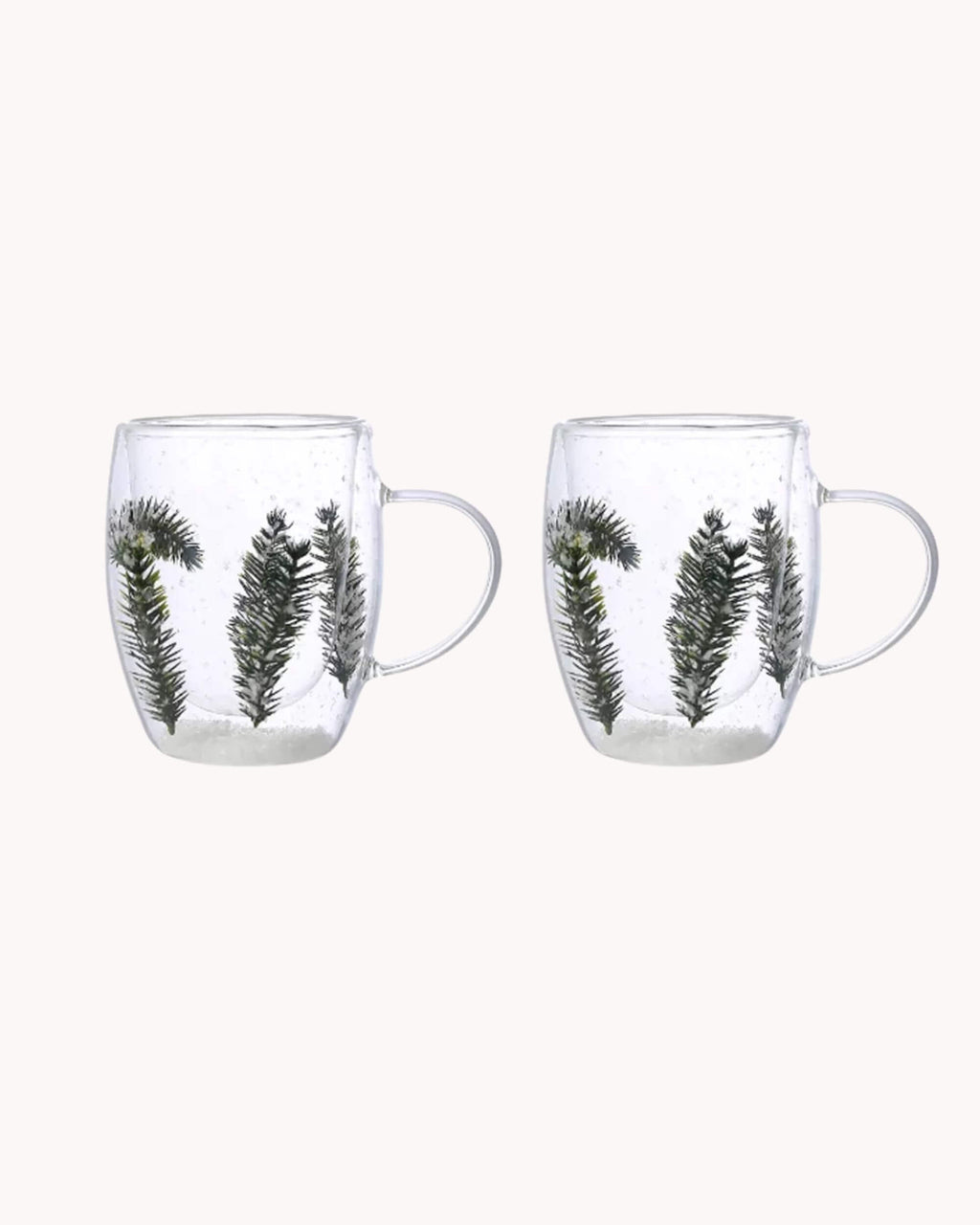 Lot de deux mugs en verre double paroi avec sapins et neige, vue packshot sur fond blanc.
