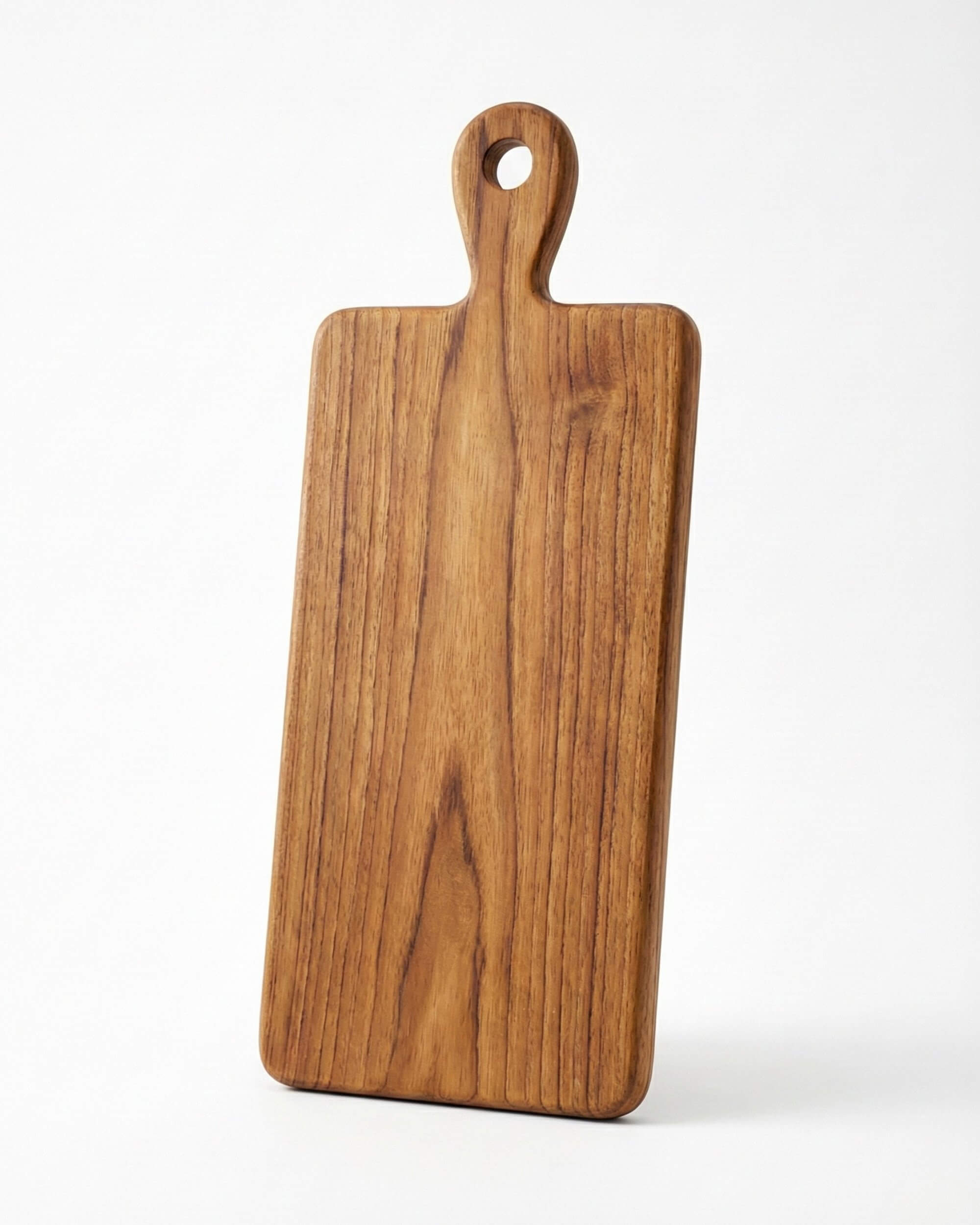 Vue de face de la planche à découper Lura sur fond blanc. Forme rectangulaire en bois massif avec manche et œillet de suspension.