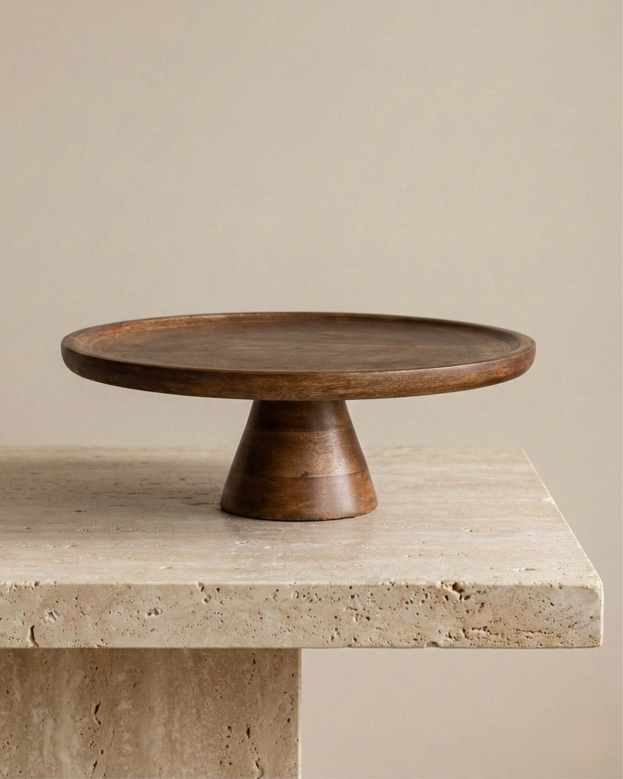 Présentoir à gâteaux sur pied Malo en bois de manguier foncé. Plateau rond de 30 cm au style rustique et élégant, idéal pour présenter pâtisseries ou fruits sur une table.