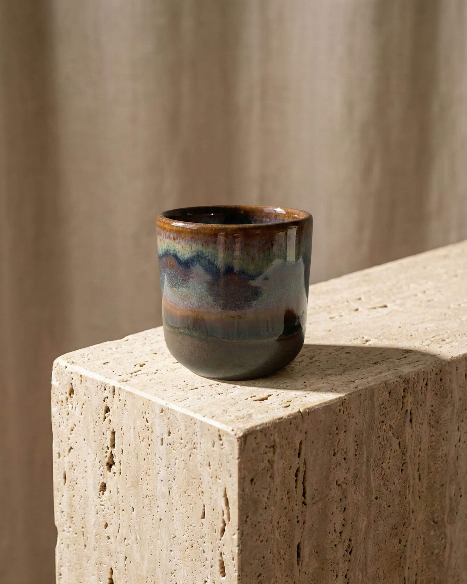 Tasse à expresso en grès émaillé Terra posée sur un bloc de pierre naturelle. Ambiance décoration artisanale et minérale.