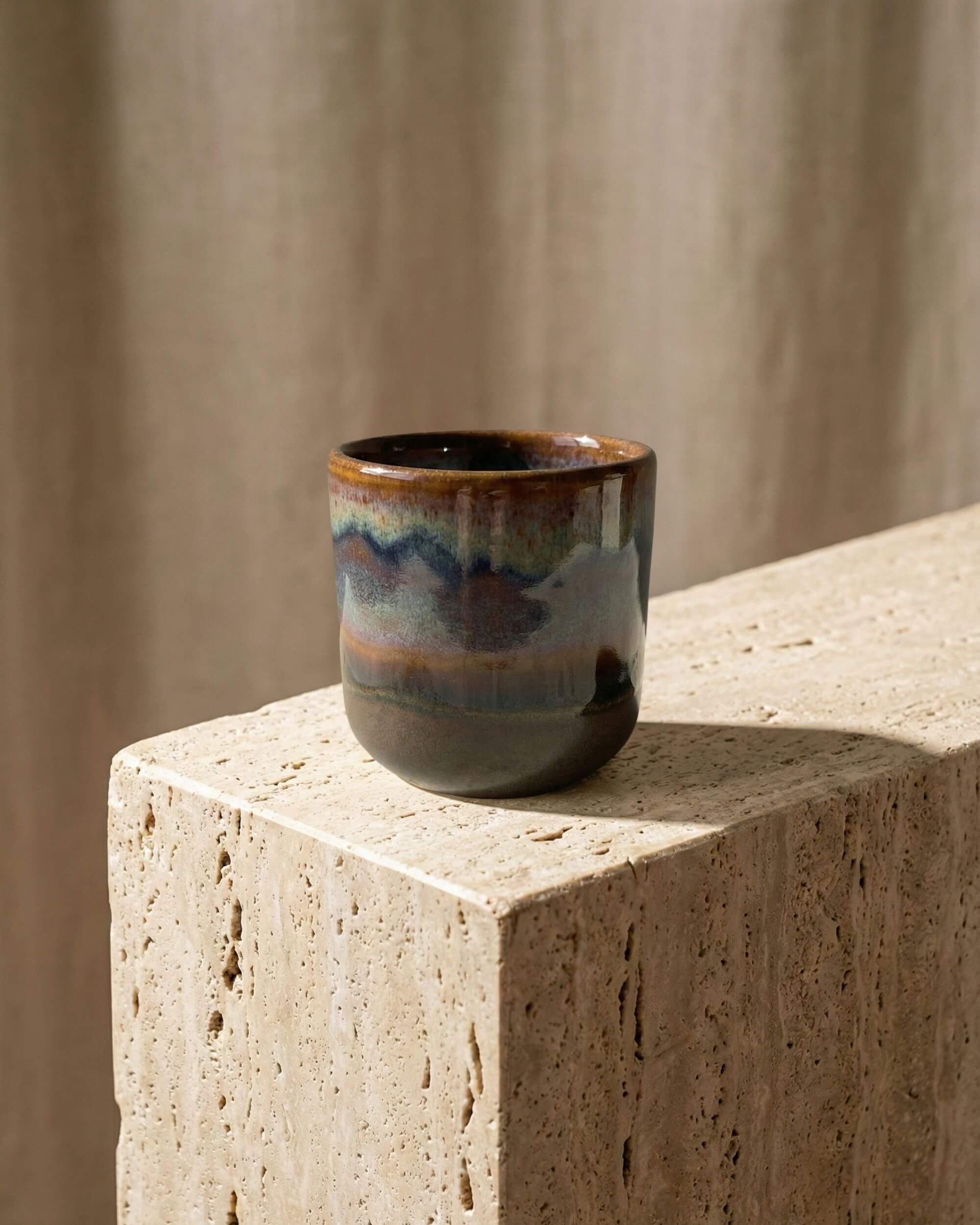 Tasse à expresso en grès émaillé Terra posée sur un bloc de pierre naturelle. Ambiance décoration artisanale et minérale.