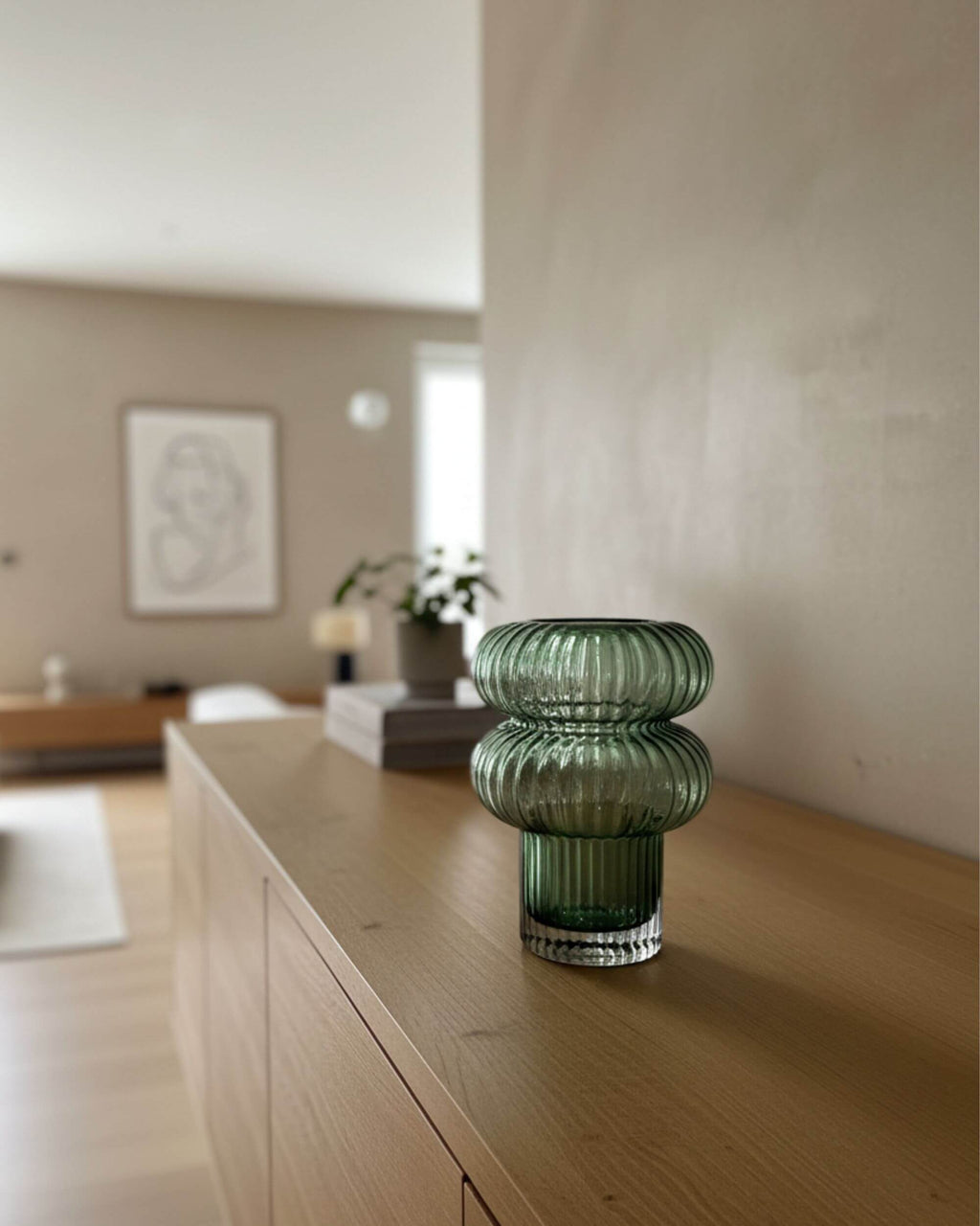 Vase AURORA artisanal en verre vert soufflé posé sur meuble en bois – design contemporain et naturel signé Blomstra Home